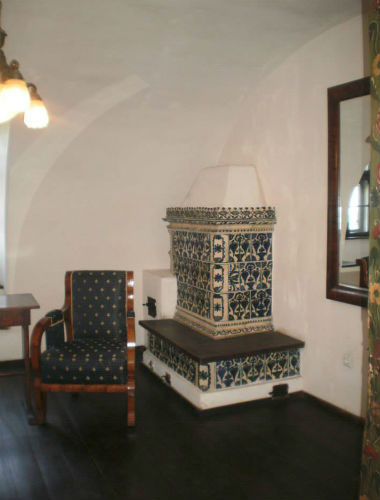 Старинная изразцовая печь в интерьере обеденной комнаты замка